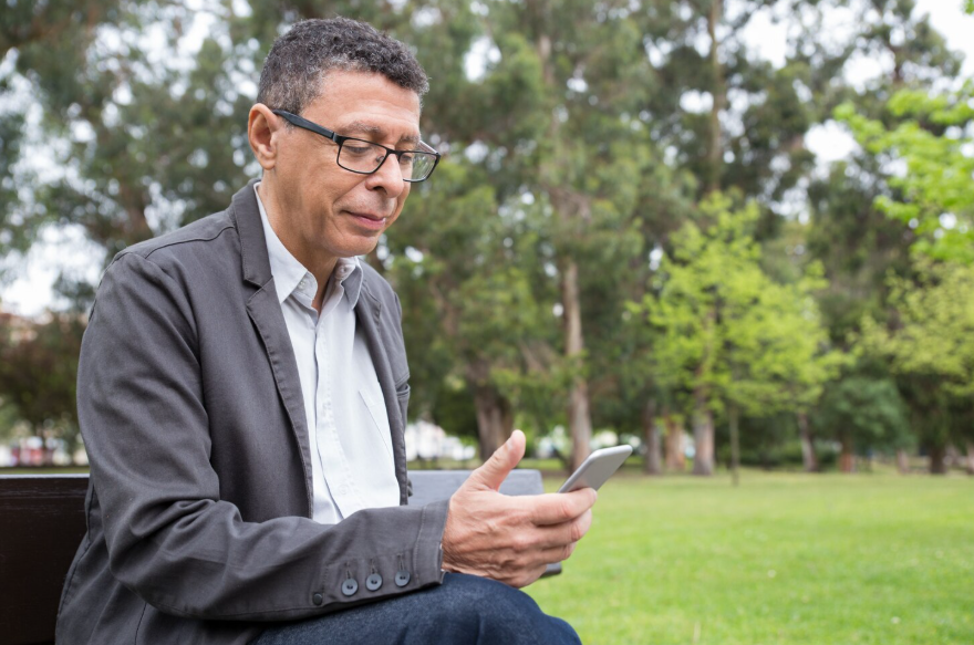 Age-related search behavior shown as a middle-aged adult uses phone to seek information.